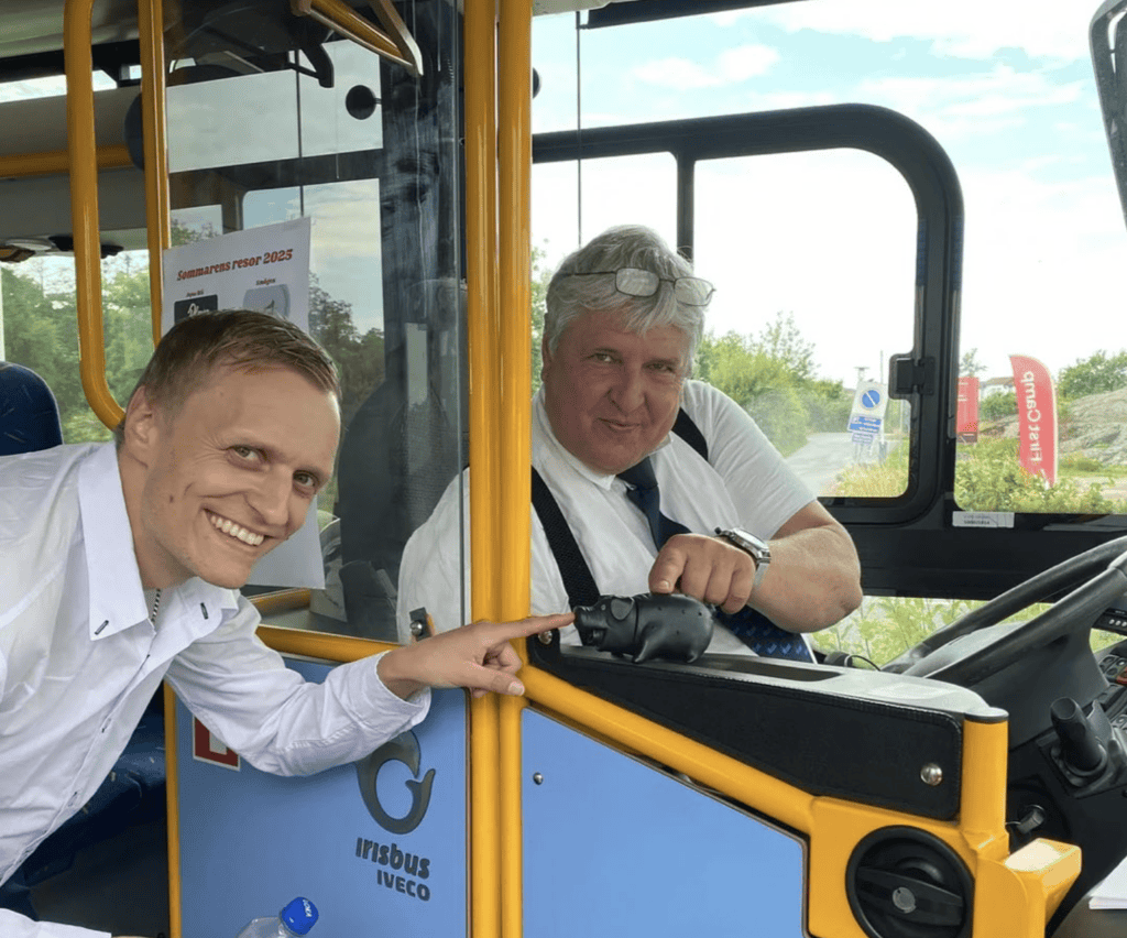 Bussförare och kund i en buss från Sparrebäcks Buss & Event, specialiserade på gruppresor och event.